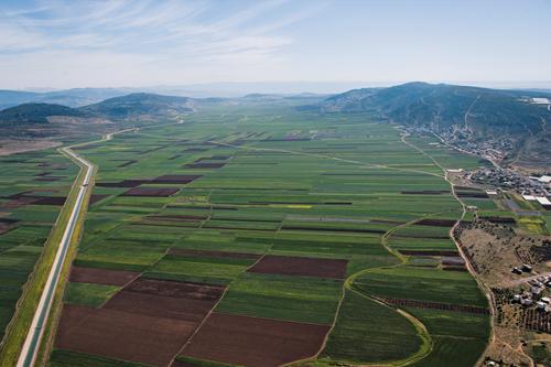 panorama looking northeast of a region including Tel el Butmeh, which just visible on the left by the closest bend in the road